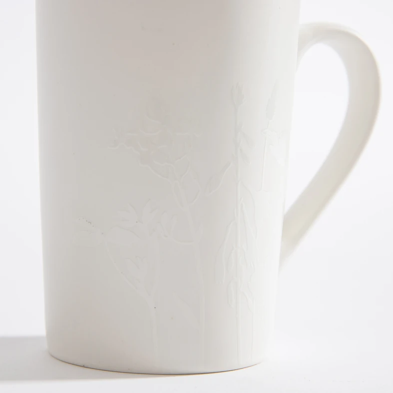 Kubek z roślinnym tłoczeniem biały 380 ml wykonany z porcelany typu New Bone China.